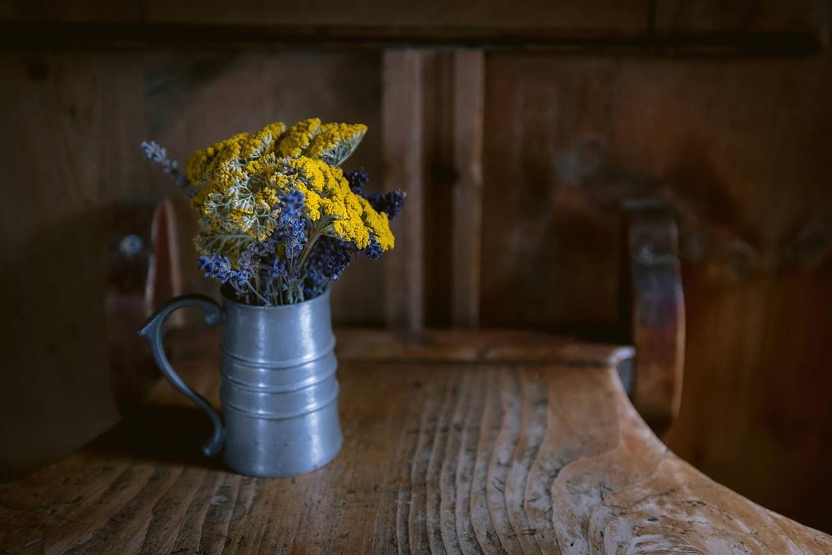 Getrocknete Blumen in Vase auf Holztisch