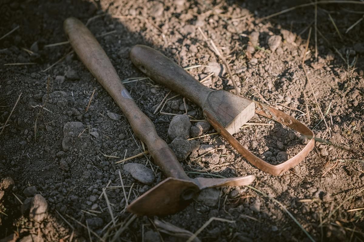 Gartenwerkzeuge auf einem sandigen Boden
