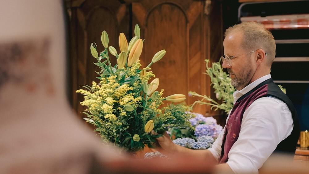 Ein Hotelmitarbeiter stellt Blumen in eine Vase