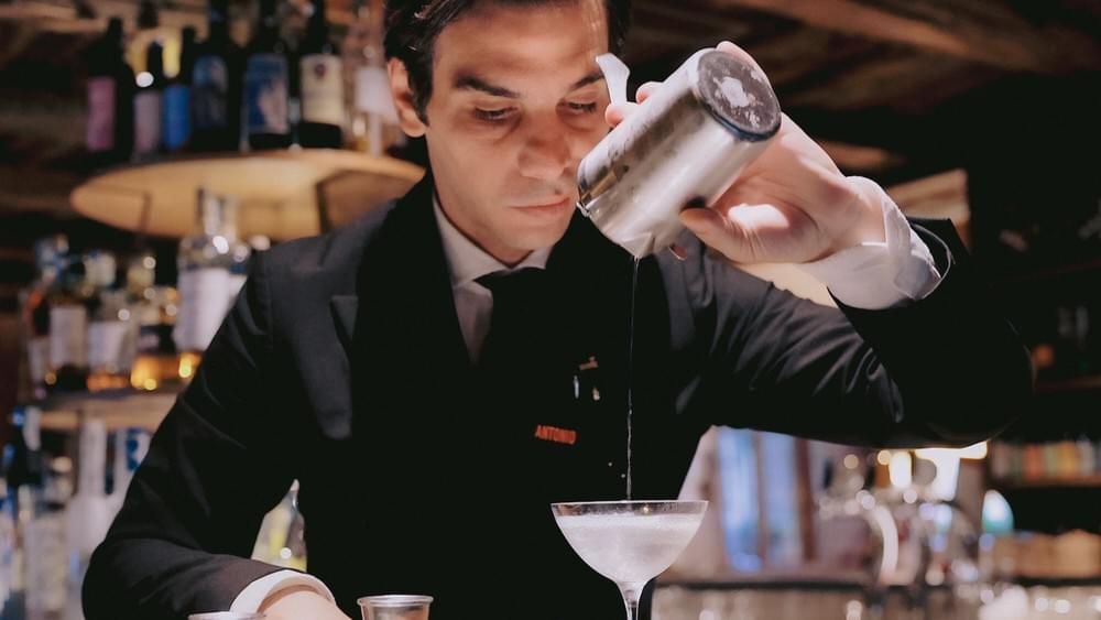 Ein Barkeeper mixt einen Drink an seiner Bar