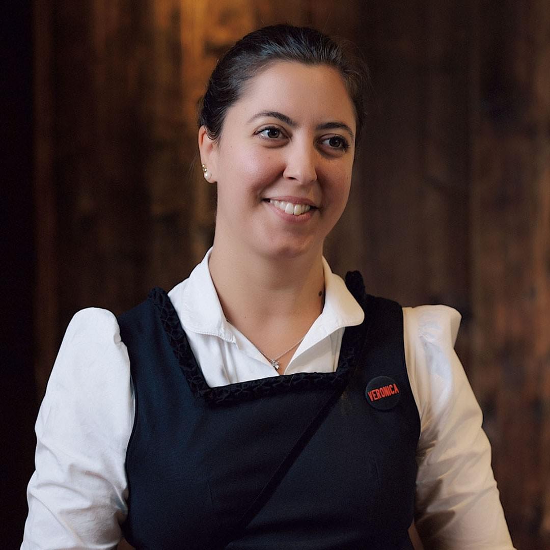 Eine lachende Frau vor einer Holzwand. Agentur für Imagefilme