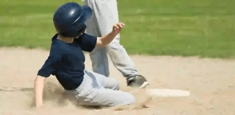 A base runner sliding into second base.