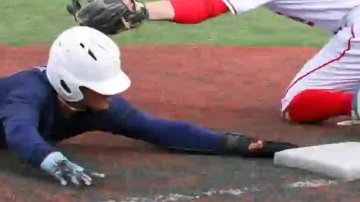 A player sliding into third base to beat the throw.