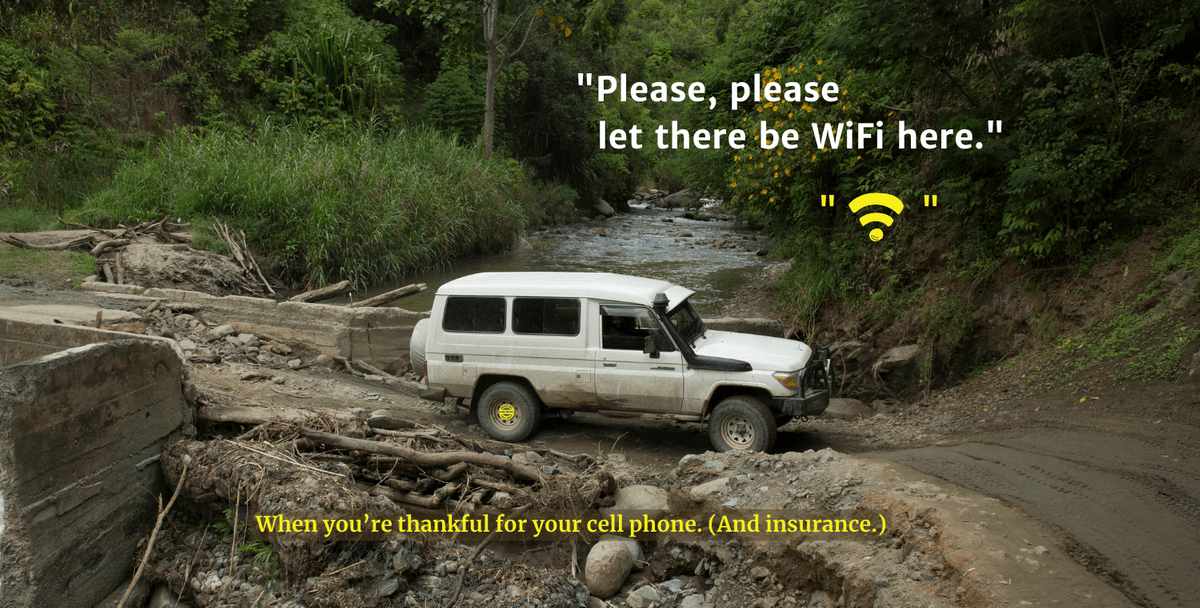 Image of a car on a road somewhere in Papua New Guinea. Text says, "Please let there be wifi." And, "When you're thankful for your cell phone (and insurance).