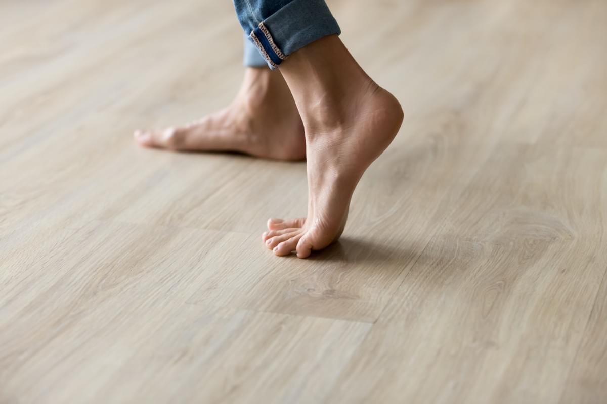 In the context of householders insurance, a person with bare feet and wearing jeans dances on the bleached timber floor of their home