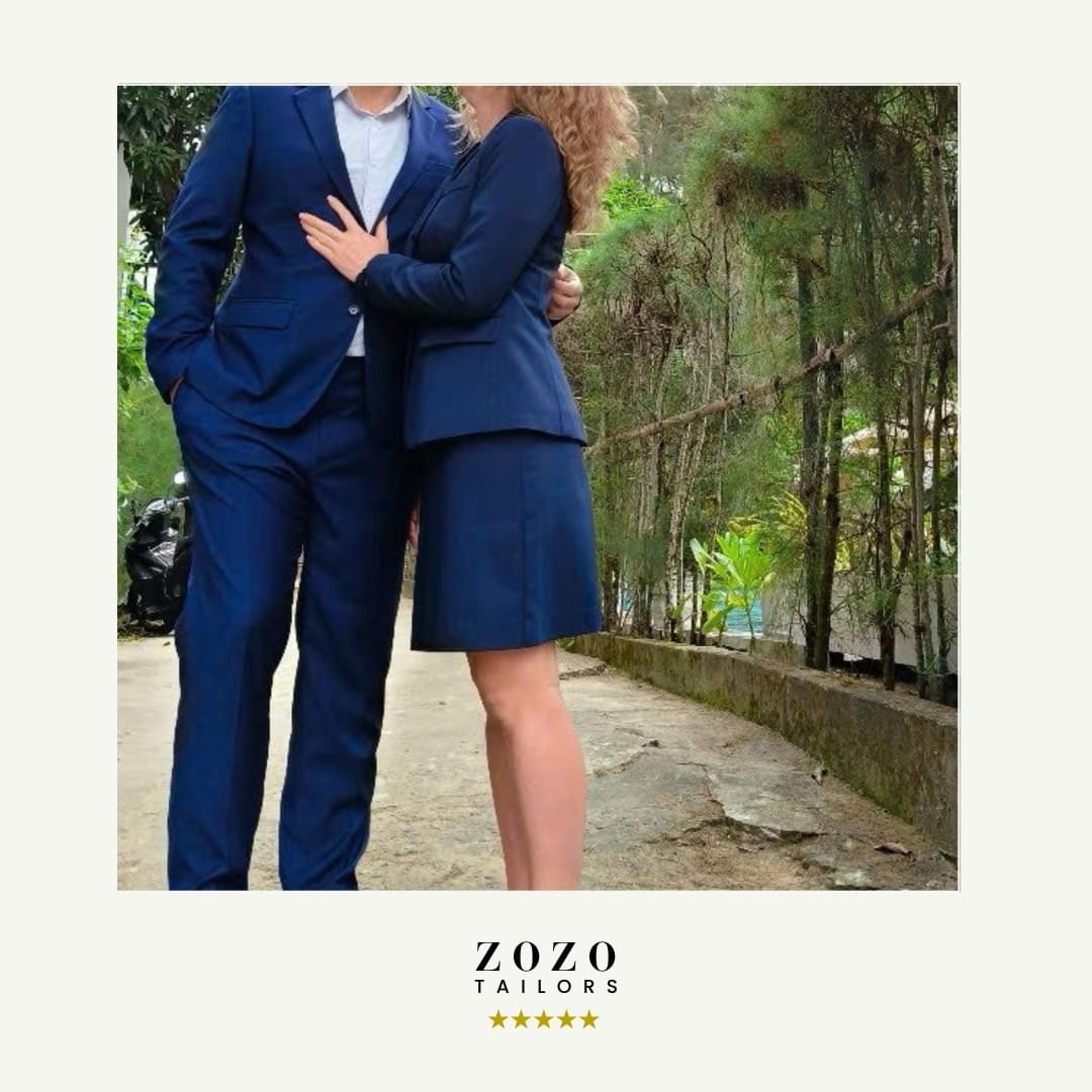Couple wearing matching navy tailored suits (his and hers)