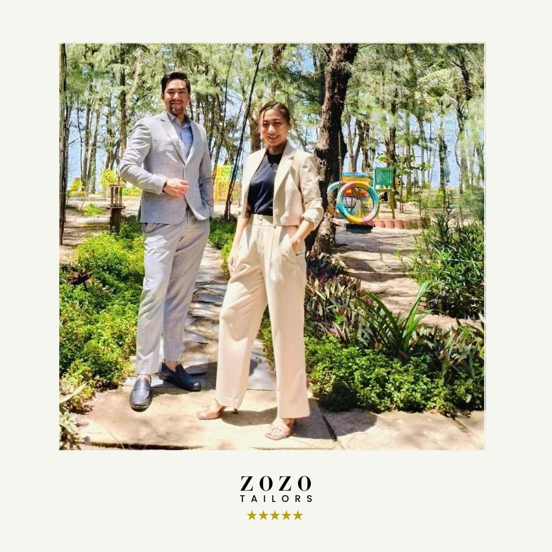 Couple wearing complementary suits: him -  light-coloured tailored suit. Her: cream tailored set
