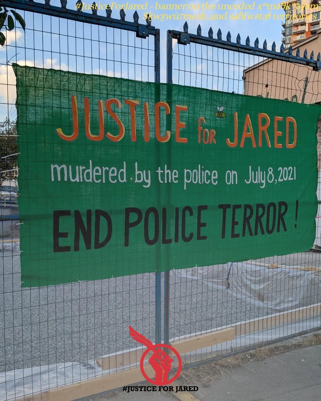 Green banner on a fence. Text: "Justice for Jared. Murdered by the police on July 8, 2021. End police terror!"