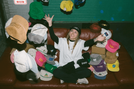 Person celebrating with a colorful collection of vintage-inspired custom snapback hats from SNAG Collective. Person celebrating with a colorful collection of vintage-inspired custom snapback hats from SNAG Collective.