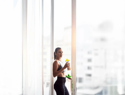 Woman measuring waist in bright room, highlighting weight loss progress and healthy lifestyle transformation Woman measuring waist in bright room, highlighting weight loss progress and healthy lifestyle transformation