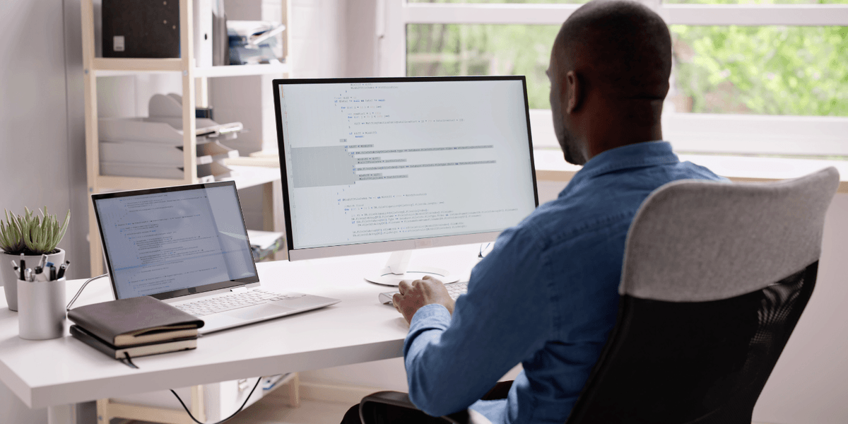 Un homme assis à son ordinateur rédige des politiques d’utilisation de l’IA.