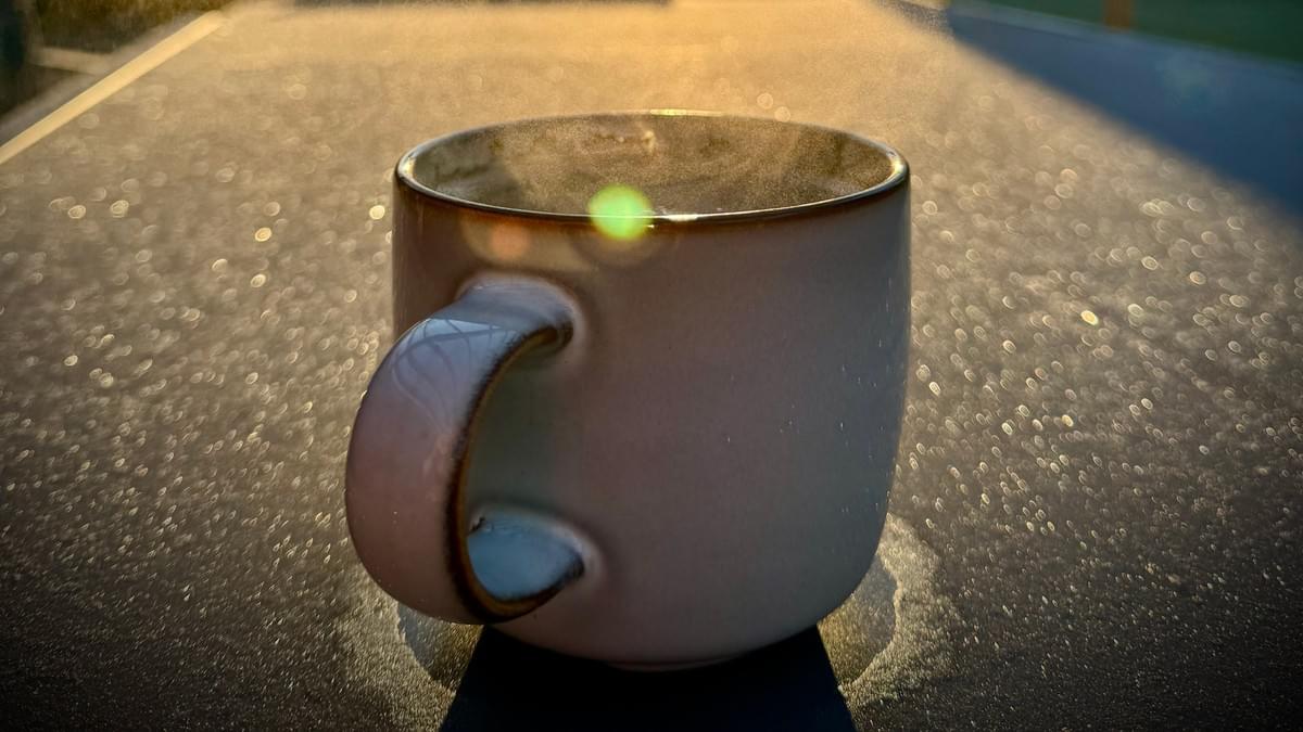 A cup of tea on an outside table lit my the morning sun A cup of tea on an outside table lit my the morning sun