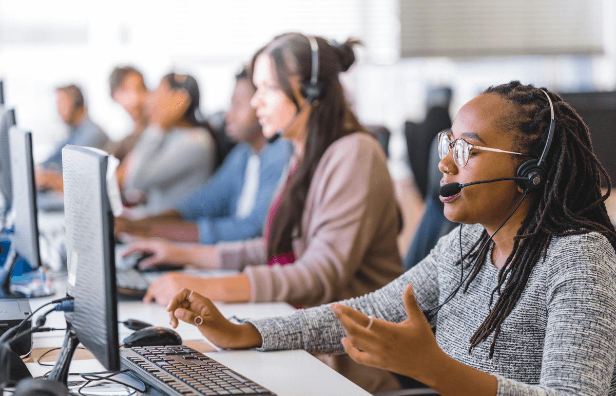 A customer service employee at her computer answering a client's call.