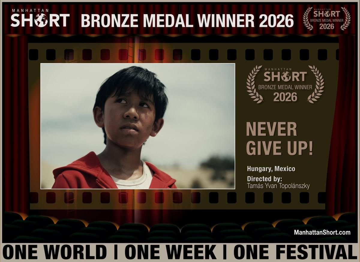 Film festival award poster announces Manhattan Short Bronze Medal Winner 2026 for “Never Give Up!” Poster features a young boy in a red jacket, laurels, filmstrip framing, director credit Tamás Yvan Topolánszky, Hungry, Mexico, and “One World | One Week | One Festival” slogan. Film festival award poster announces Manhattan Short Bronze Medal Winner 2026 for “Never Give Up!” Poster features a young boy in a red jacket, laurels, filmstrip framing, director credit Tamás Yvan Topolánszky, Hungry, Mexico, and “One World | One Week | One Festival” slogan.