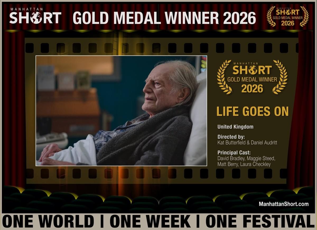 Film festival award poster announcing “Life Goes On” as a Manhattan Short Gold Medal Winner 2026. Poster features an elderly man in profile, filmstrip borders, gold laurel graphics, UK origin, director credits, and “One World | One Week | One Festival” tagline. Film festival award poster announcing “Life Goes On” as a Manhattan Short Gold Medal Winner 2026. Poster features an elderly man in profile, filmstrip borders, gold laurel graphics, UK origin, director credits, and “One World | One Week | One Festival” tagline.