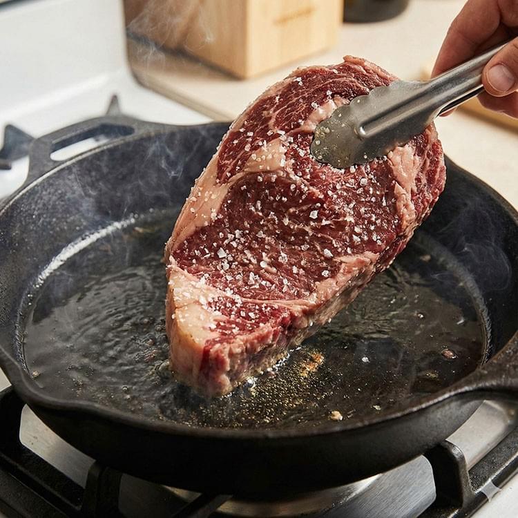 將牛排表面的水分用廚房紙巾徹底擦乾。架好鍋子、油熱到冒煙後，拿起牛排，這時才撒鹽，然後「立刻」下鍋 拷貝