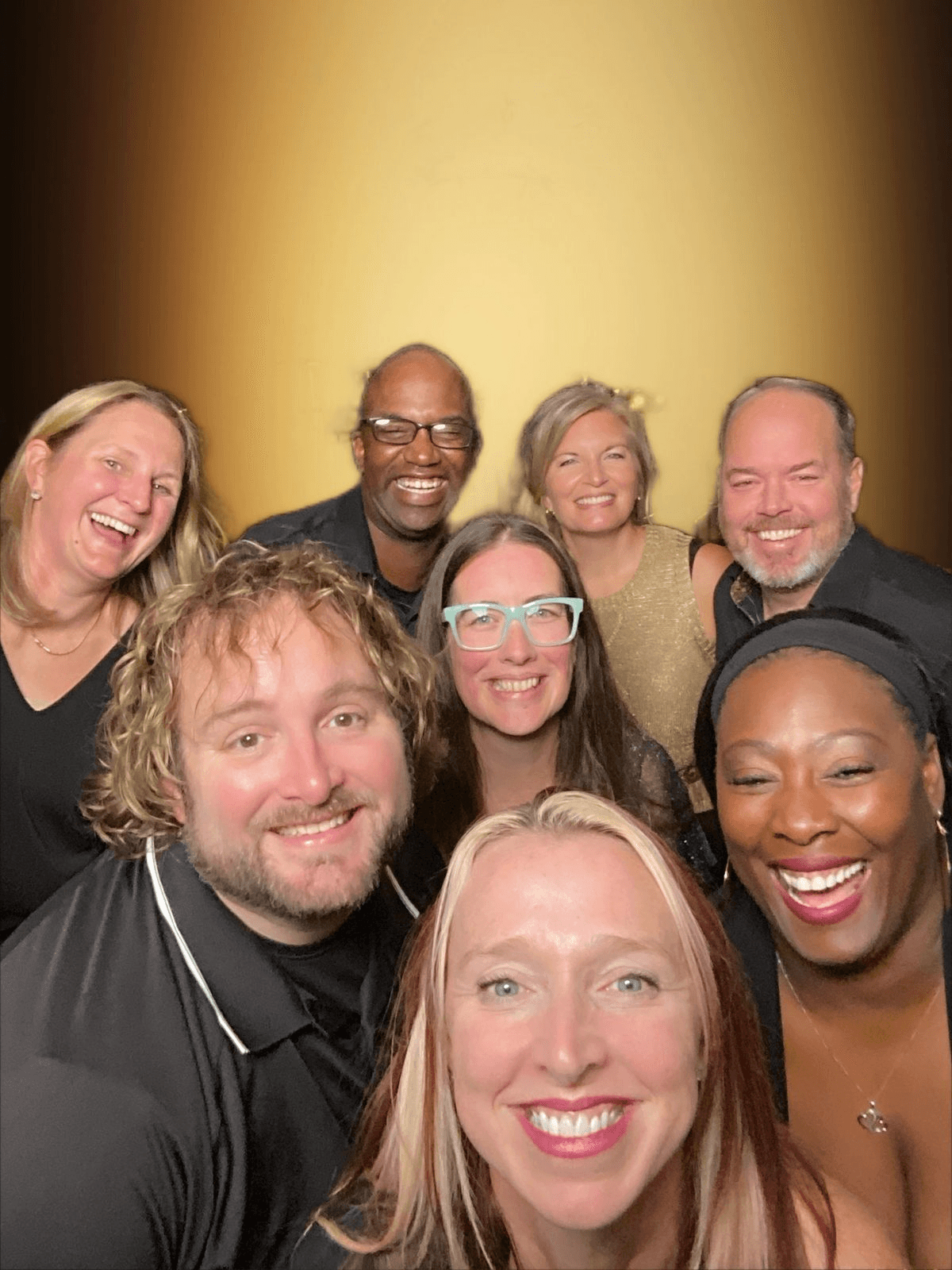 Nine friends laughing in a close group photo at an Indianapolis reception