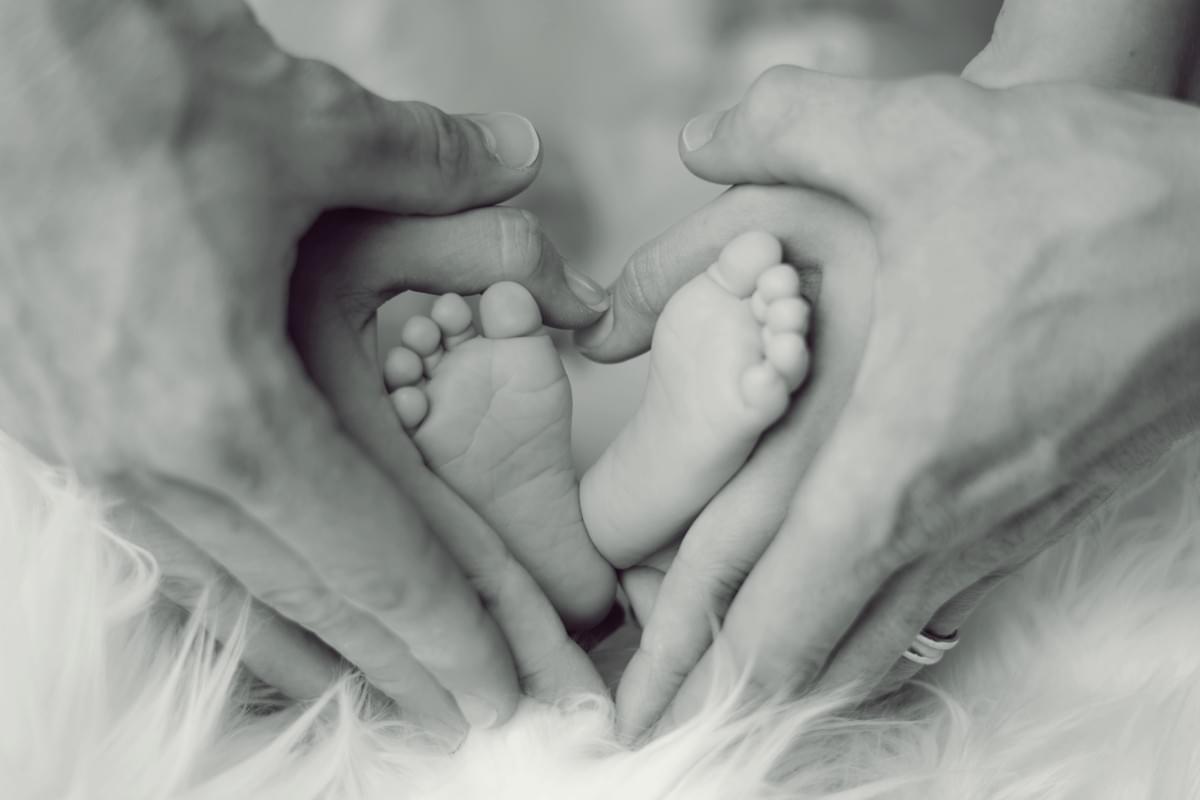 Photo of parents holding a baby's feet.