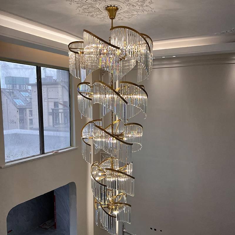 Golden double spiral chandelier for modern staircases with a sculptural look.