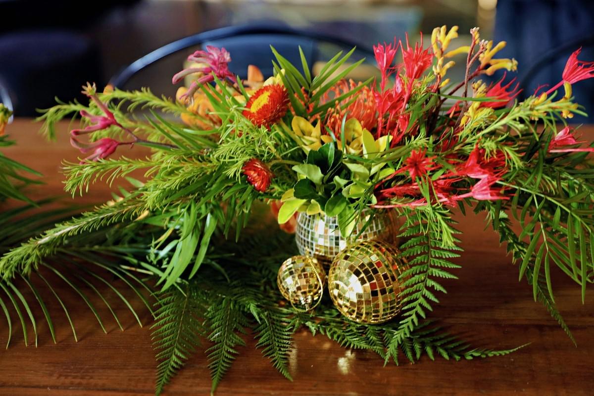 Textural and tropical floral centerpiece with disco ball accents