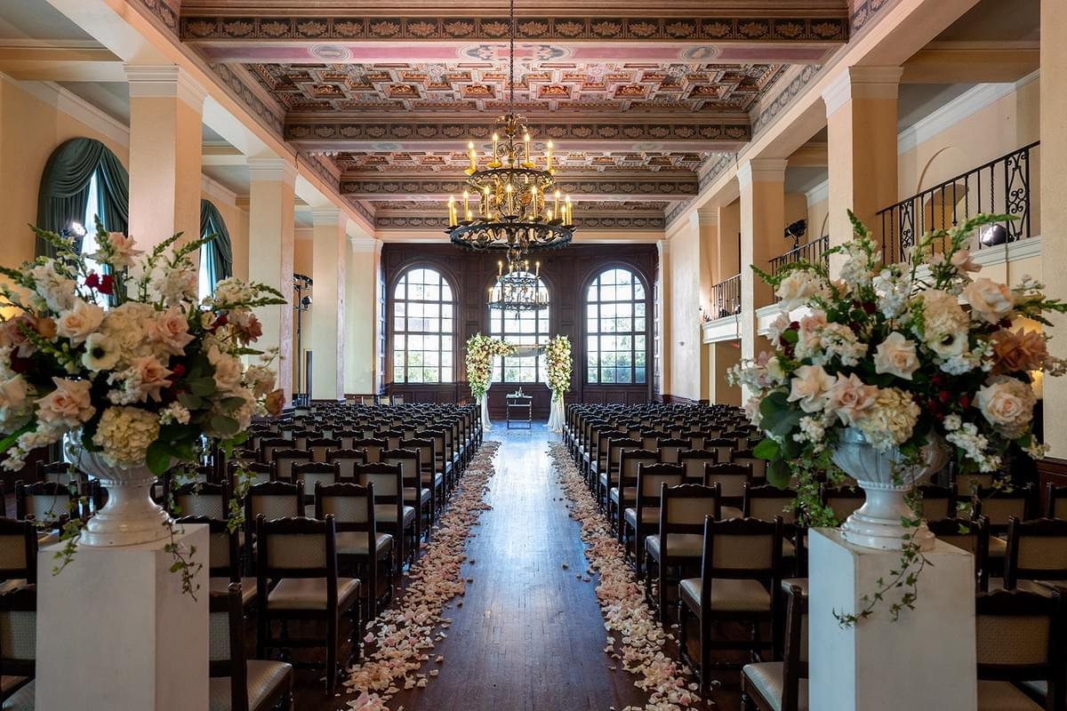 Wedding ceremony with floral pedastals and petals down the aisle