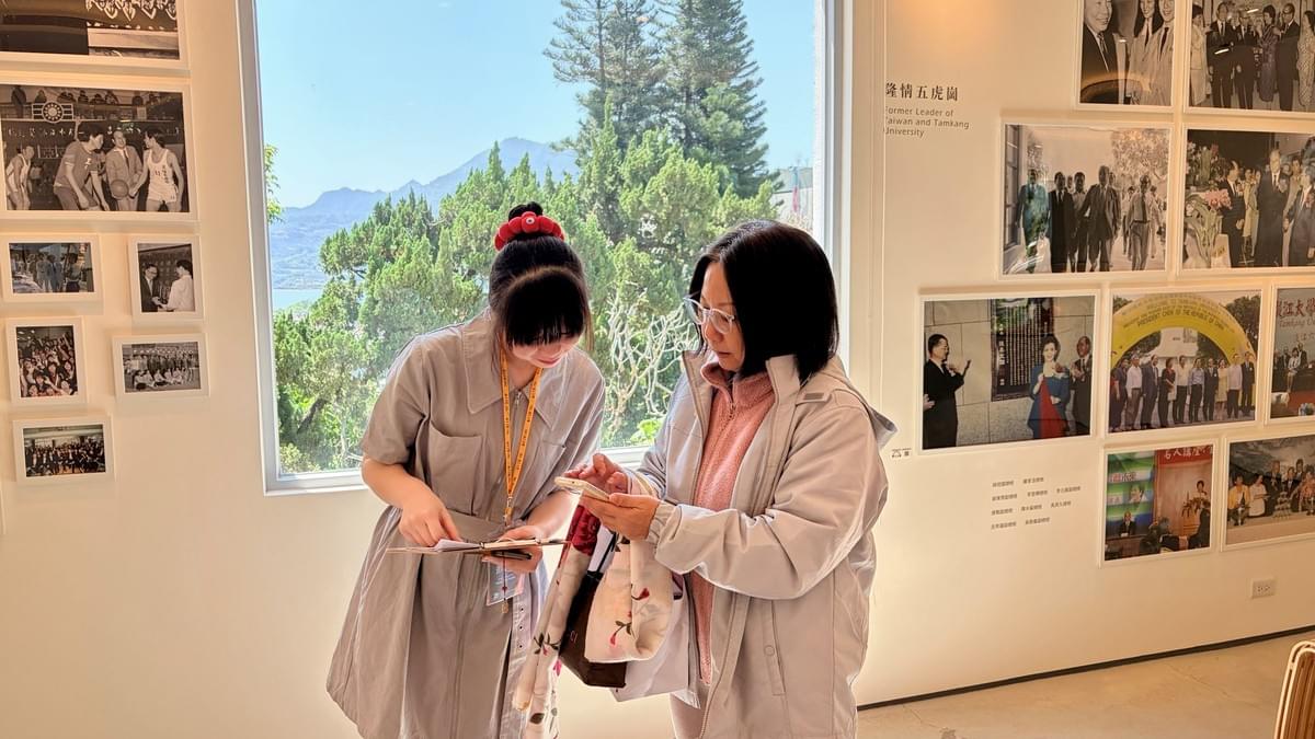 工讀生資圖系彭紫彤同學（左一）為EMBA校友進行導覽，談及校內著名景點時，學姊亦熱情分享李雙澤紀念碑的位置與相關照片，勾起對校園時光的共同回憶。（攝影／圖書館何政興）