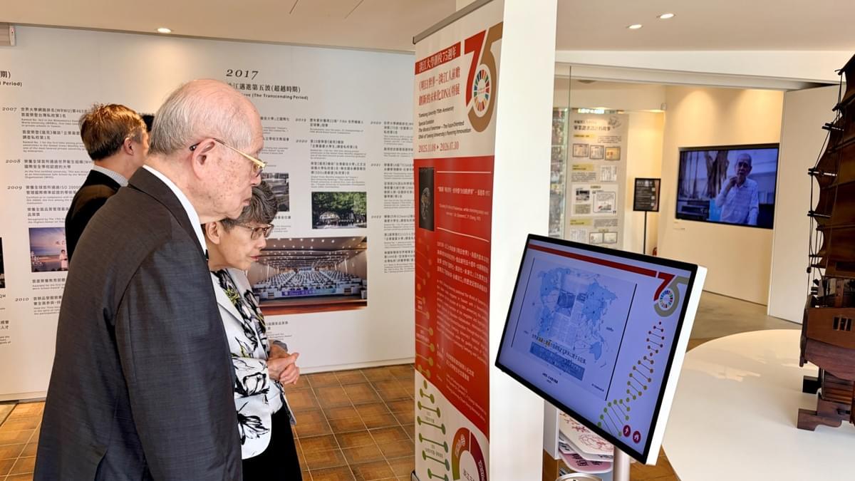 野依良治教授伉儷觀看《明日世界－淡江人前瞻創新的未來化DNA》特展日文介紹影片，該影片由 Google NotebookLM 分析並精選《明日世界》雜誌內容生成，用以呈現本校三化教育理念與特展策展內涵。（攝影／校史組何政興）