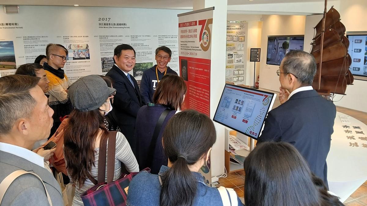 圖書館校史組館員何政興（左一）於「大事紀」展區向來賓介紹本校發展歷程。（攝影／圖書館周曉彤）