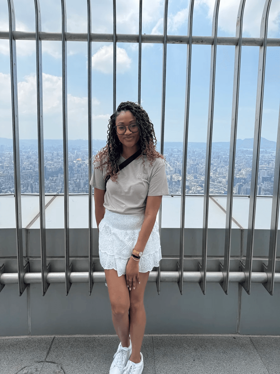 Brit Thompson standing in front of the edge of the Taipei 101 tower in Taipei, Taiwan