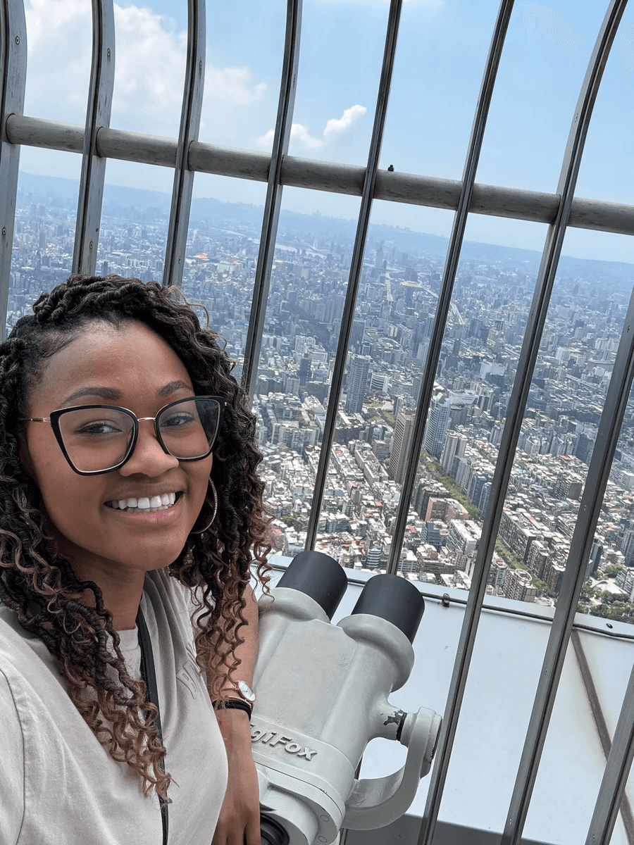 Brit Thompson selfie with telescope at the top of the Taipei 101 in Taiwan