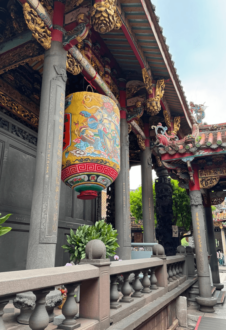 A stunning lantern in the hall of the Lungshan Temple in Taipei Taiwan and dragon on the roof