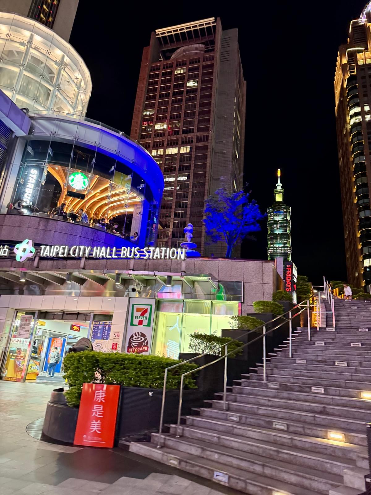 Taipei City Hall Bus Station entrance with 711 and Taipei 101 in background