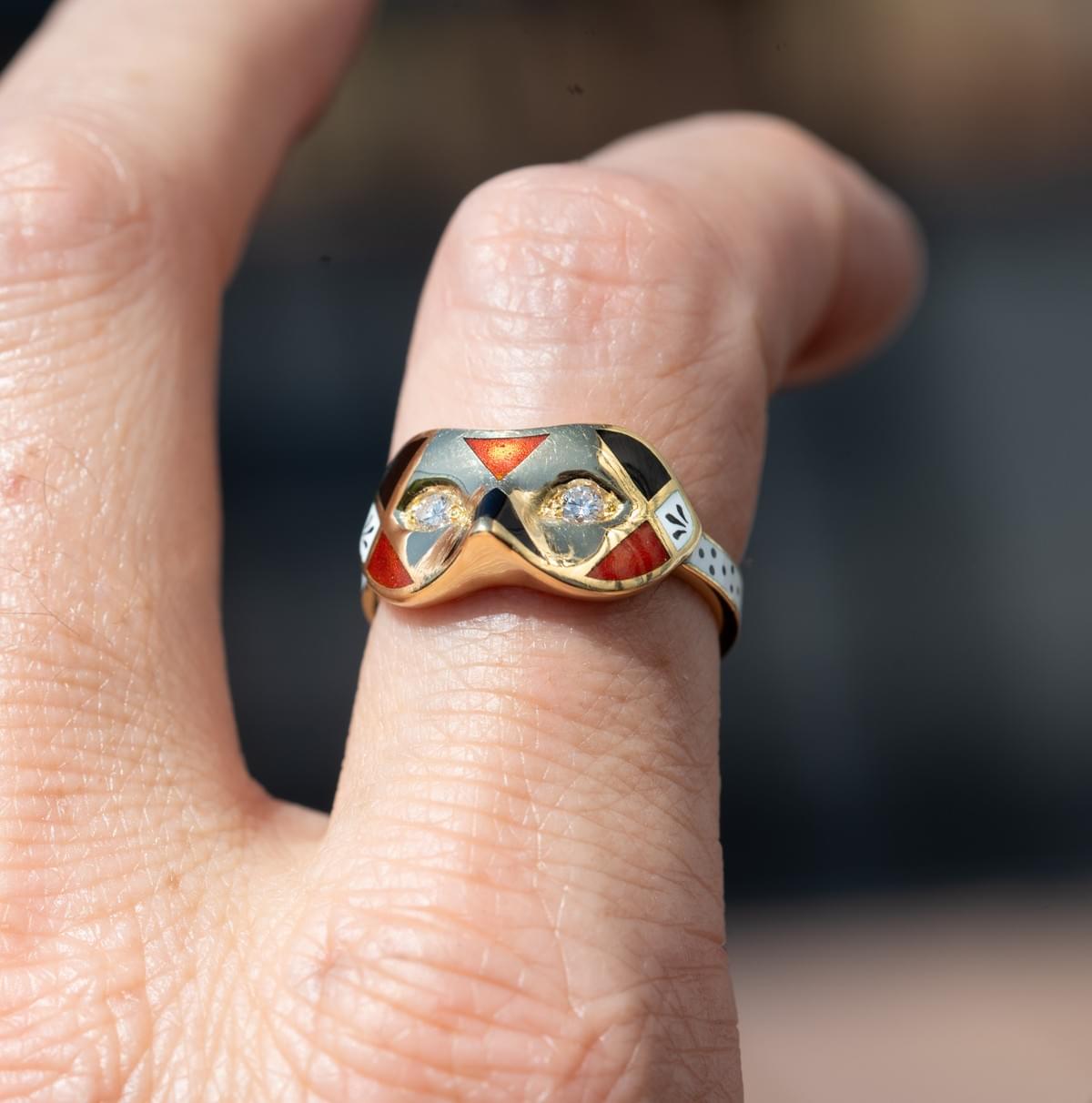 A diamond, enamel and gold mask ring