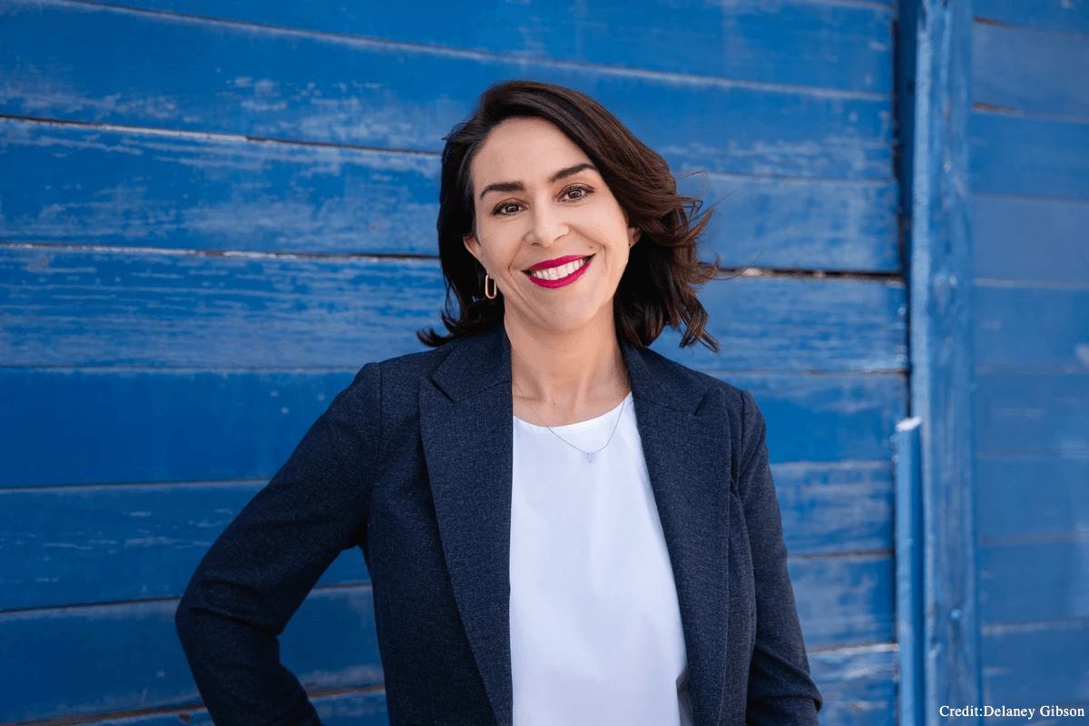 headshot of woman in front of blue wall