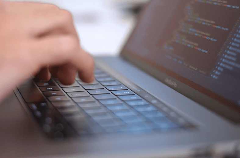 programista stron internetowych kodujący na laptopie