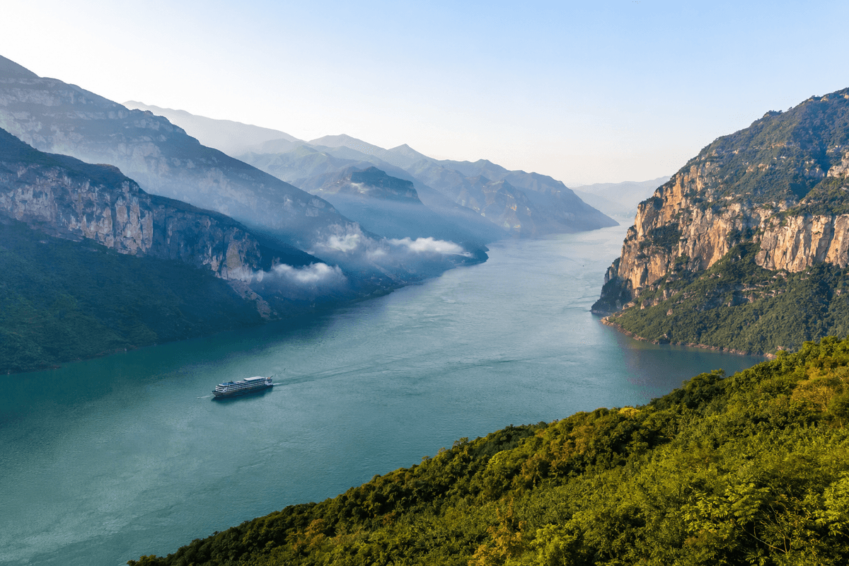 Cruise ship sailing through the mountainous Three Gorges on the Yangtze River in China