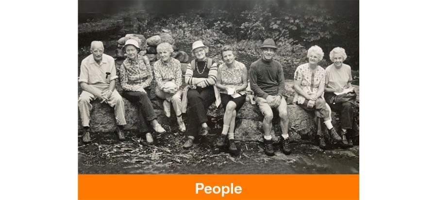 People - A black and white photo of a group of people sitting on rocks.