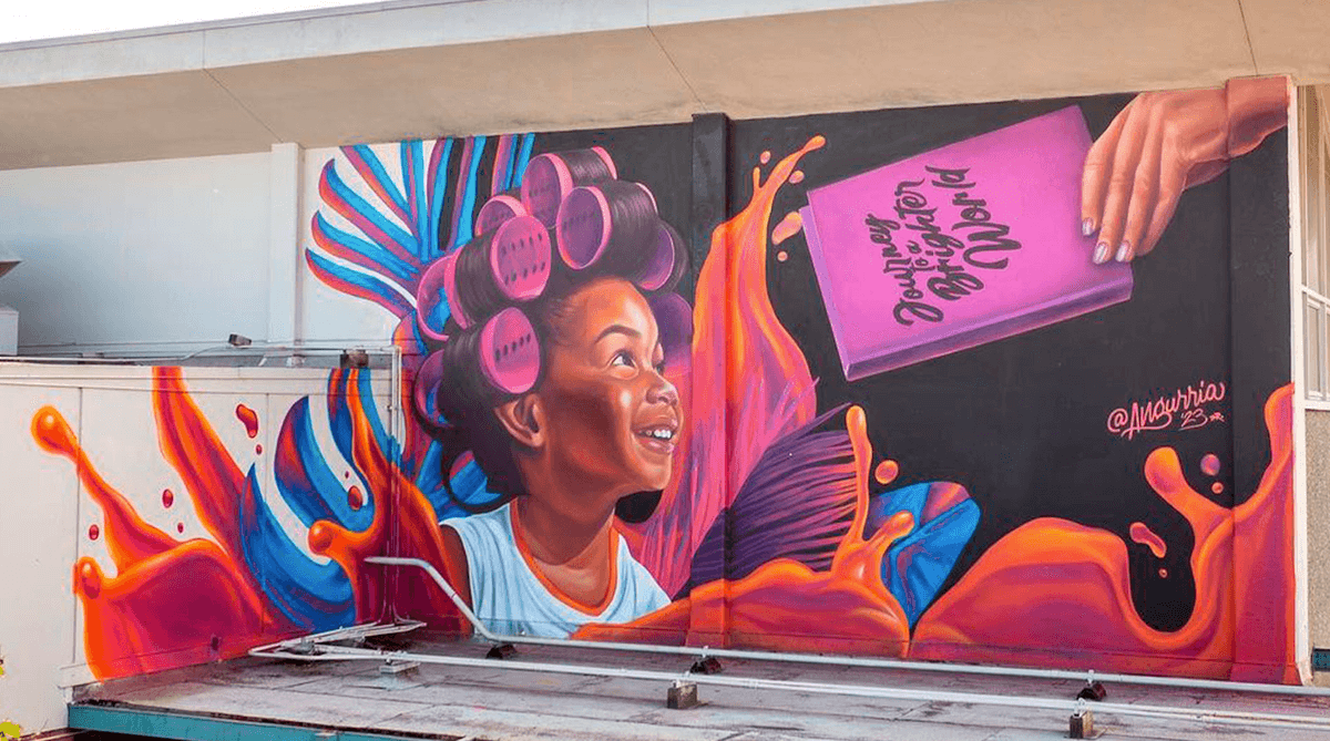 Large mural by Angurria at Sacramento Wide Open Walls 2023 featuring a young girl with hair rollers and vibrant flowing colors
