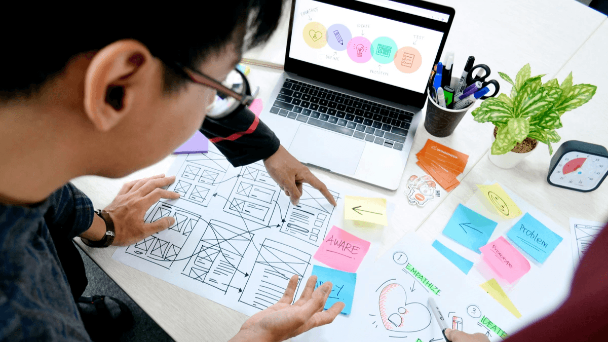 Designers reviewing website wireframes and a human-centered design process