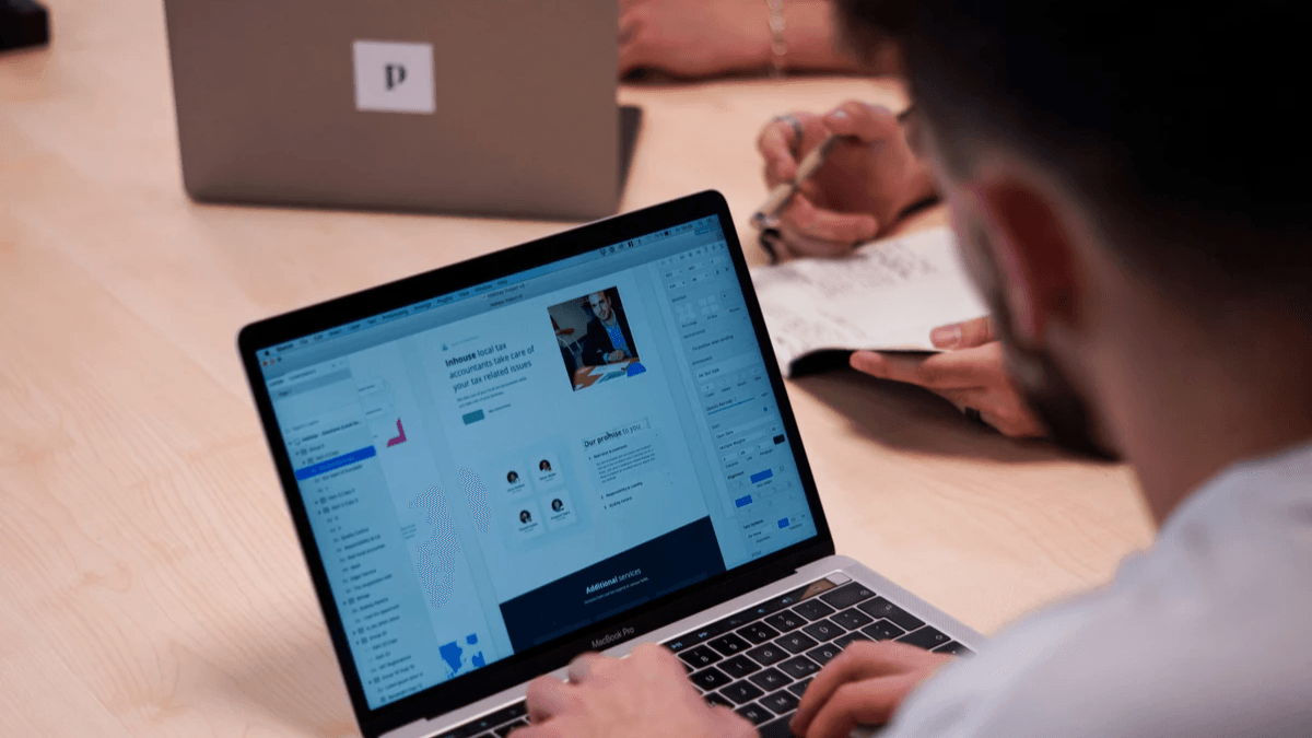 Web design team reviewing page sections and conversion elements on a laptop