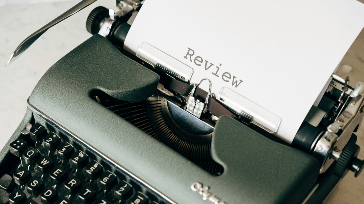 A typewriter with the word Review typed on a sheet of paper