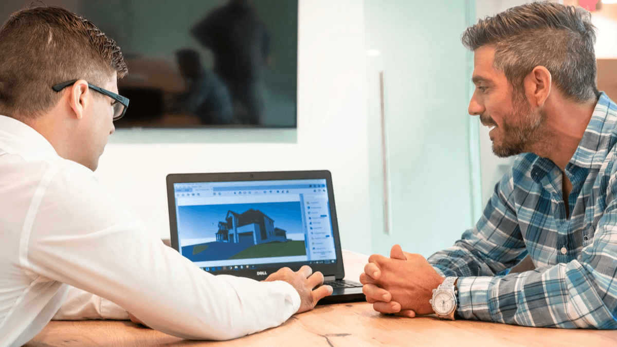  A service provider and client reviewing plans together beside a laptop