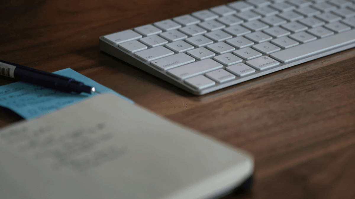  Marketing strategy written in a planner beside a computer keyboard