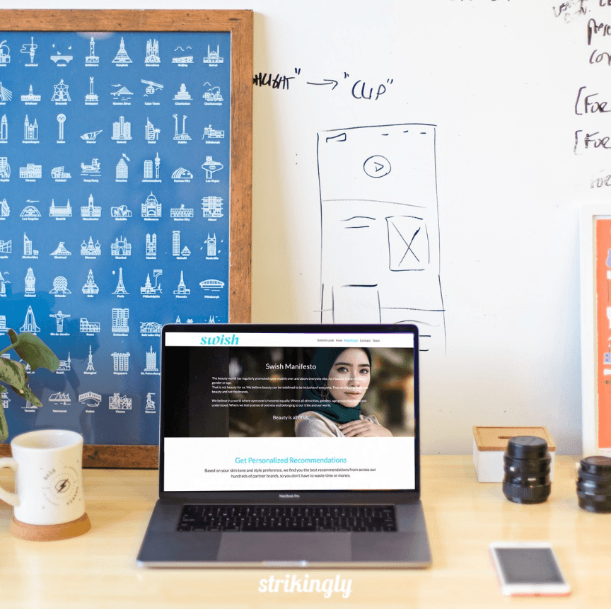 A Strikingly website displayed on a laptop in a content planning workspace