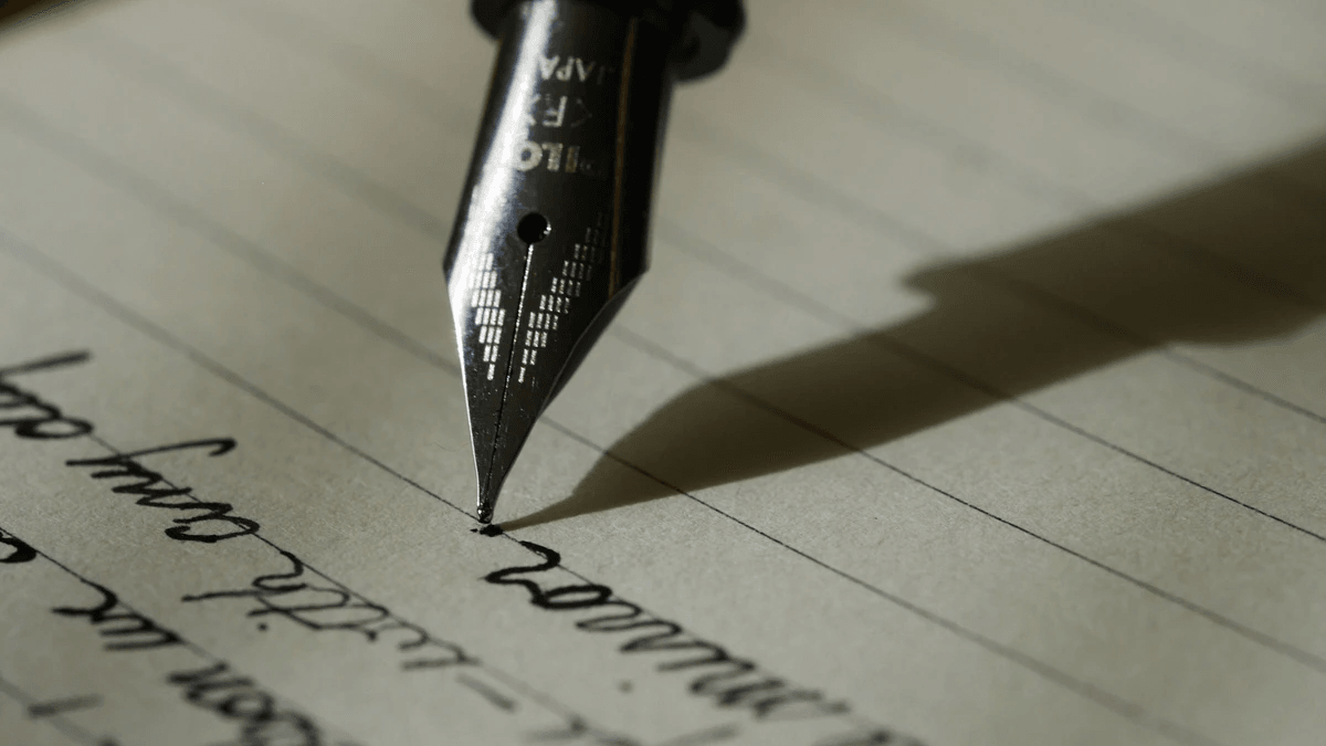 A fountain pen drafting clear website messaging on paper