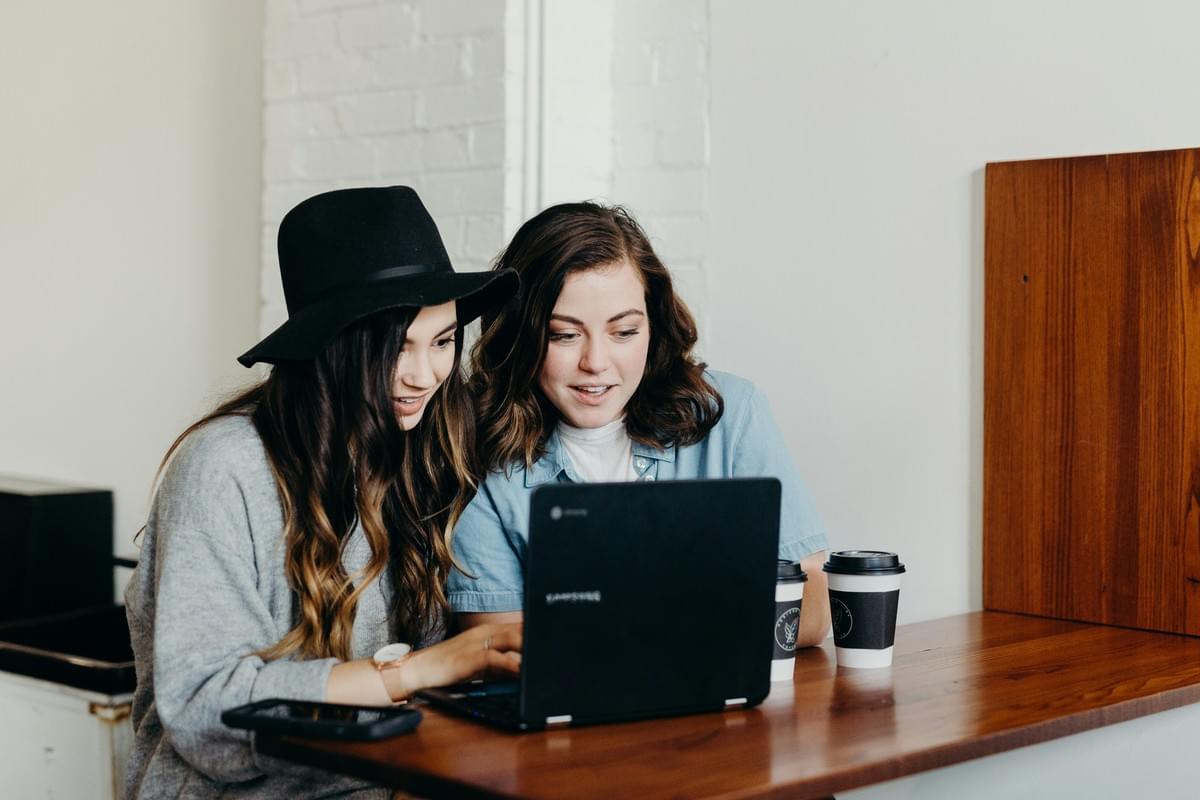 Two colleagues reviewing website reporting together on a laptop