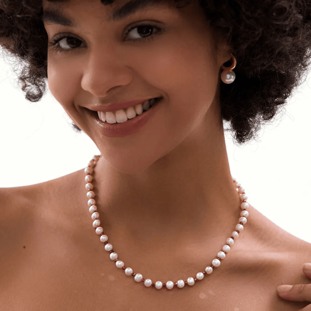 Stylish woman wearing a beautiful white pearl necklace choker.