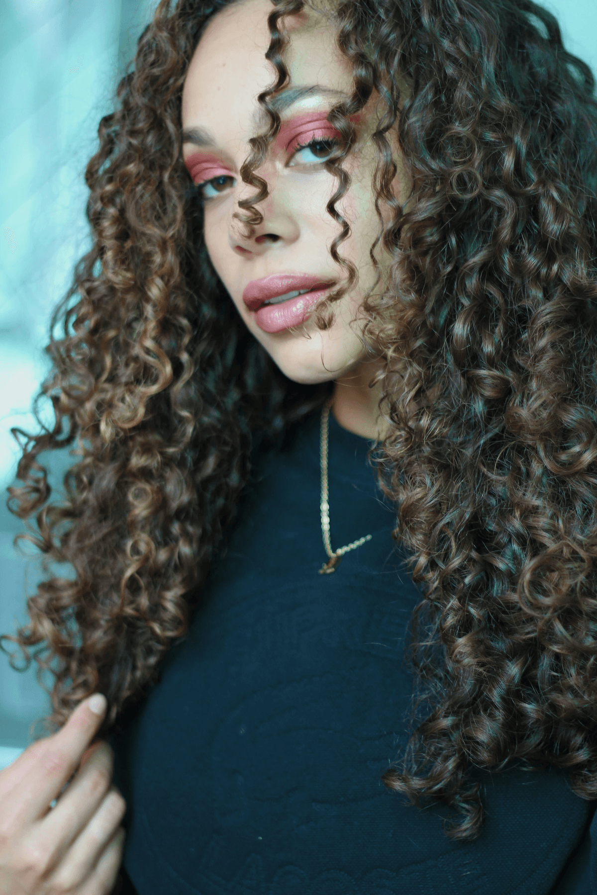 Balayage curly hair extensions close-up showing seamless blending and rich texture.