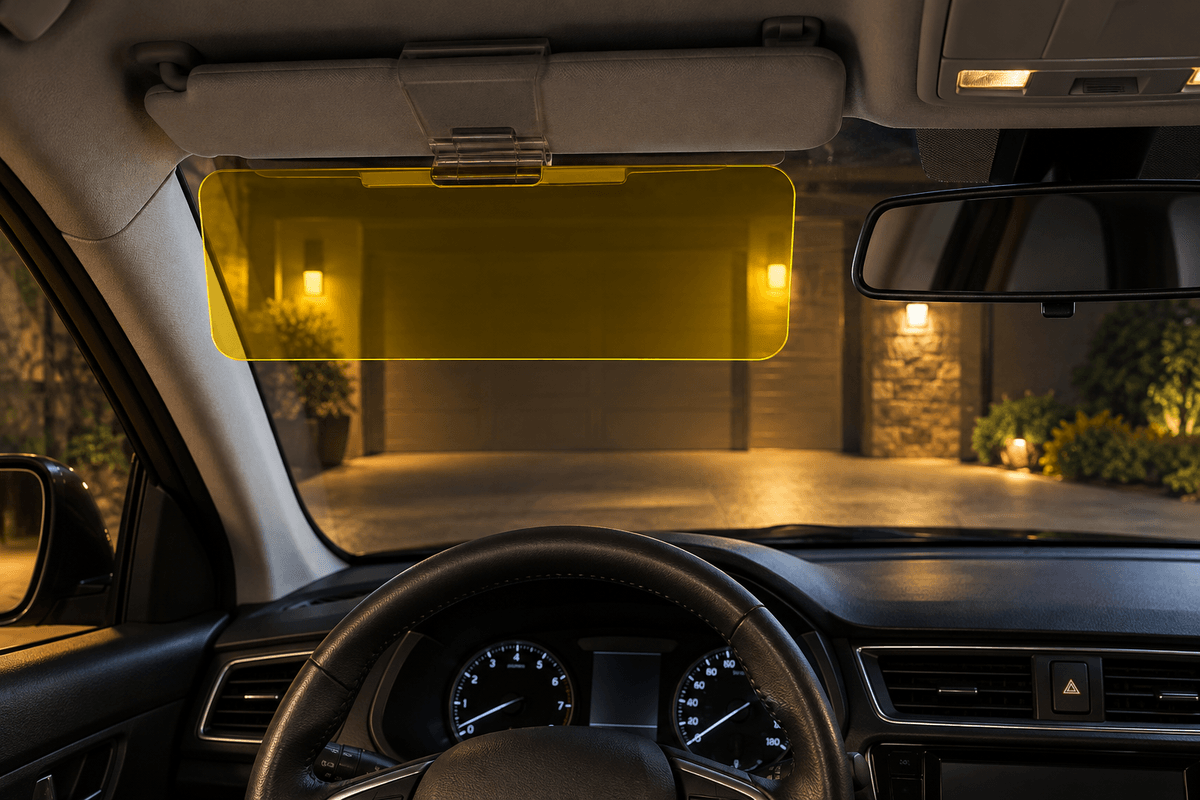 Yellow anti glare visor panel lowered at night in a parked car with clear mirror view