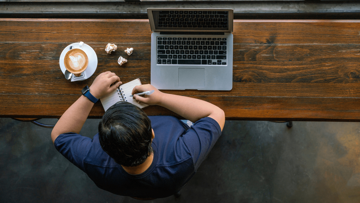 Man Writing Notes About Content Optimization on Notepad